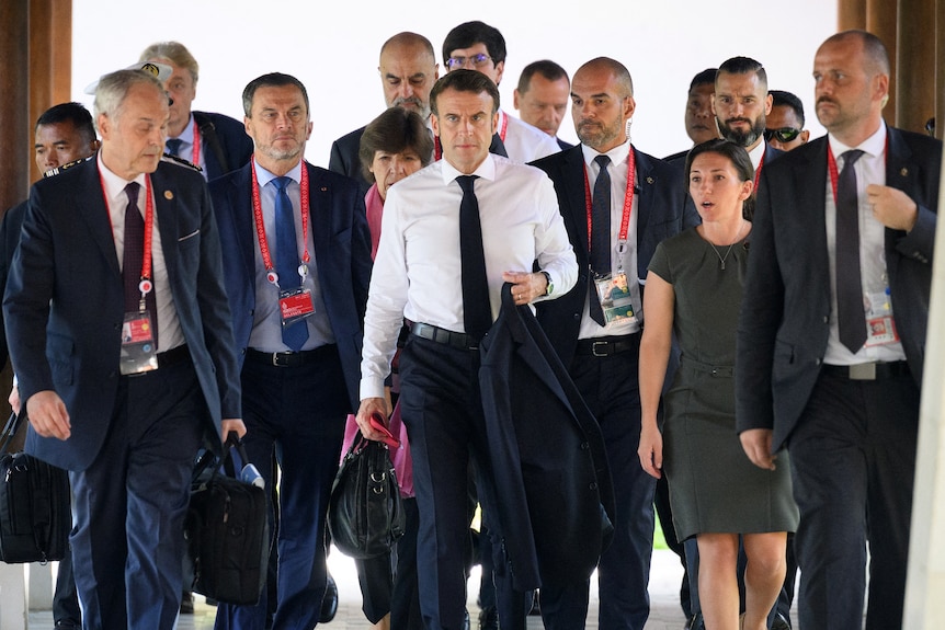 Emmanuel Macron surrounded by staff 