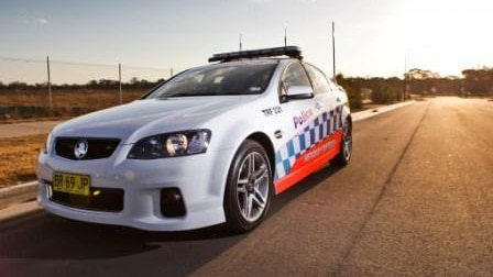 A New South Wales police car parked on the side of a road.
