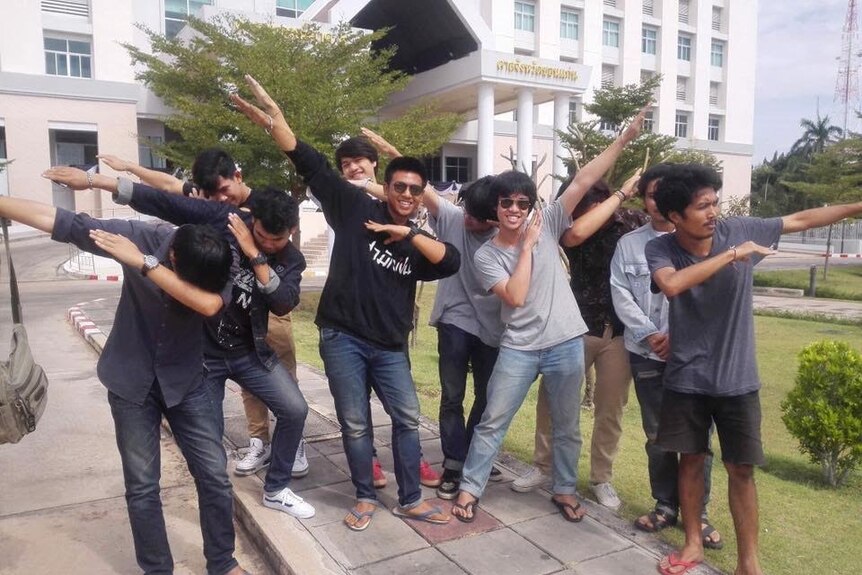 Student activist 'Pai', centre in black top, celebrates his bail with friends outside the Khon Kaen court