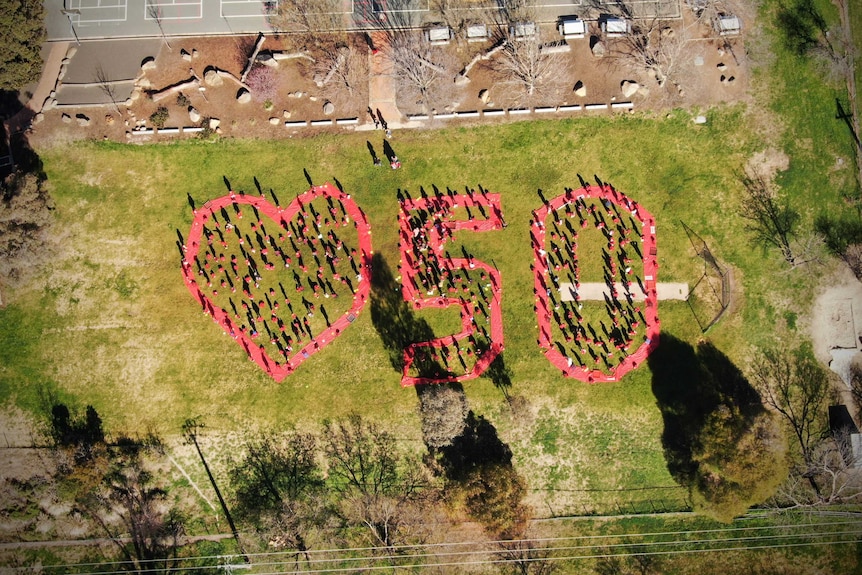 An aerial photo of a big heart and number 50 made by students.