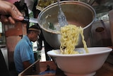 A vendor prepares instant noodles at a stall in Jakarta.