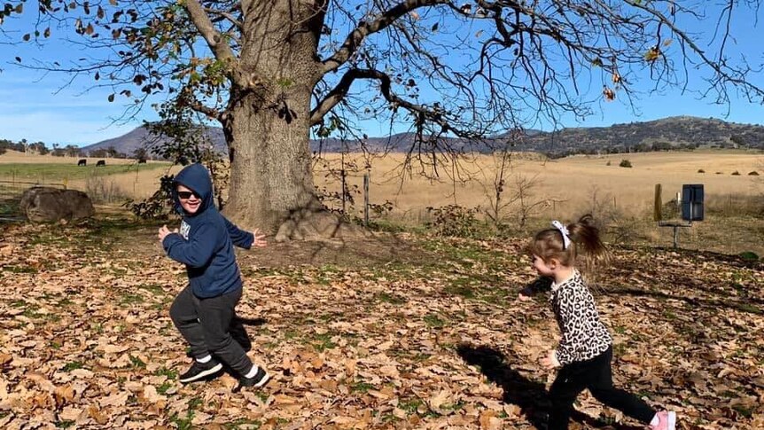 Charlotte chases Jeremy over dead leaves.