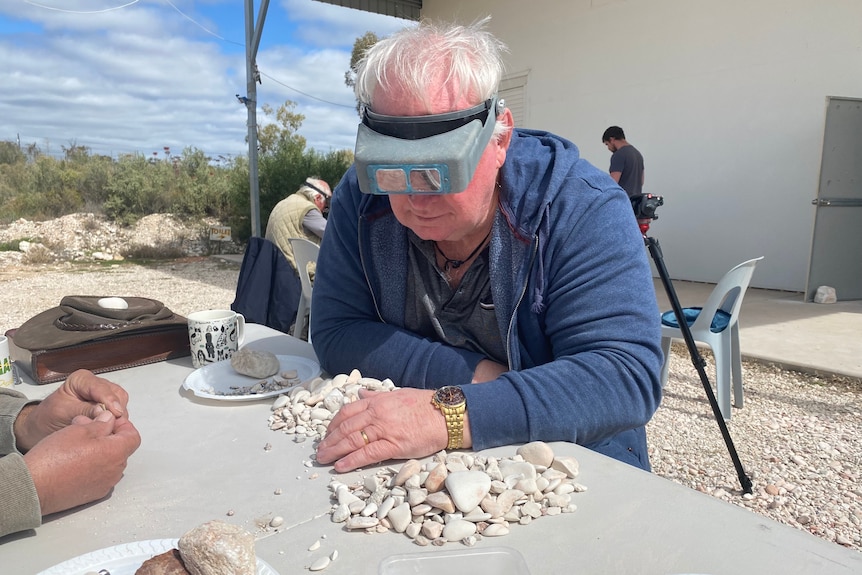 A man sifts through rocks for fossils in Lightning Ridge.