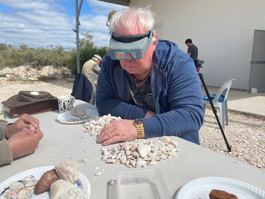 A man sifts rocks for fossils at Lightning Ridge.