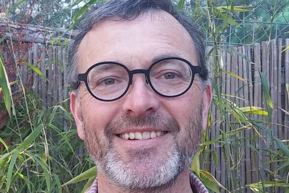 A headshot of Richard Rowe in a garden.