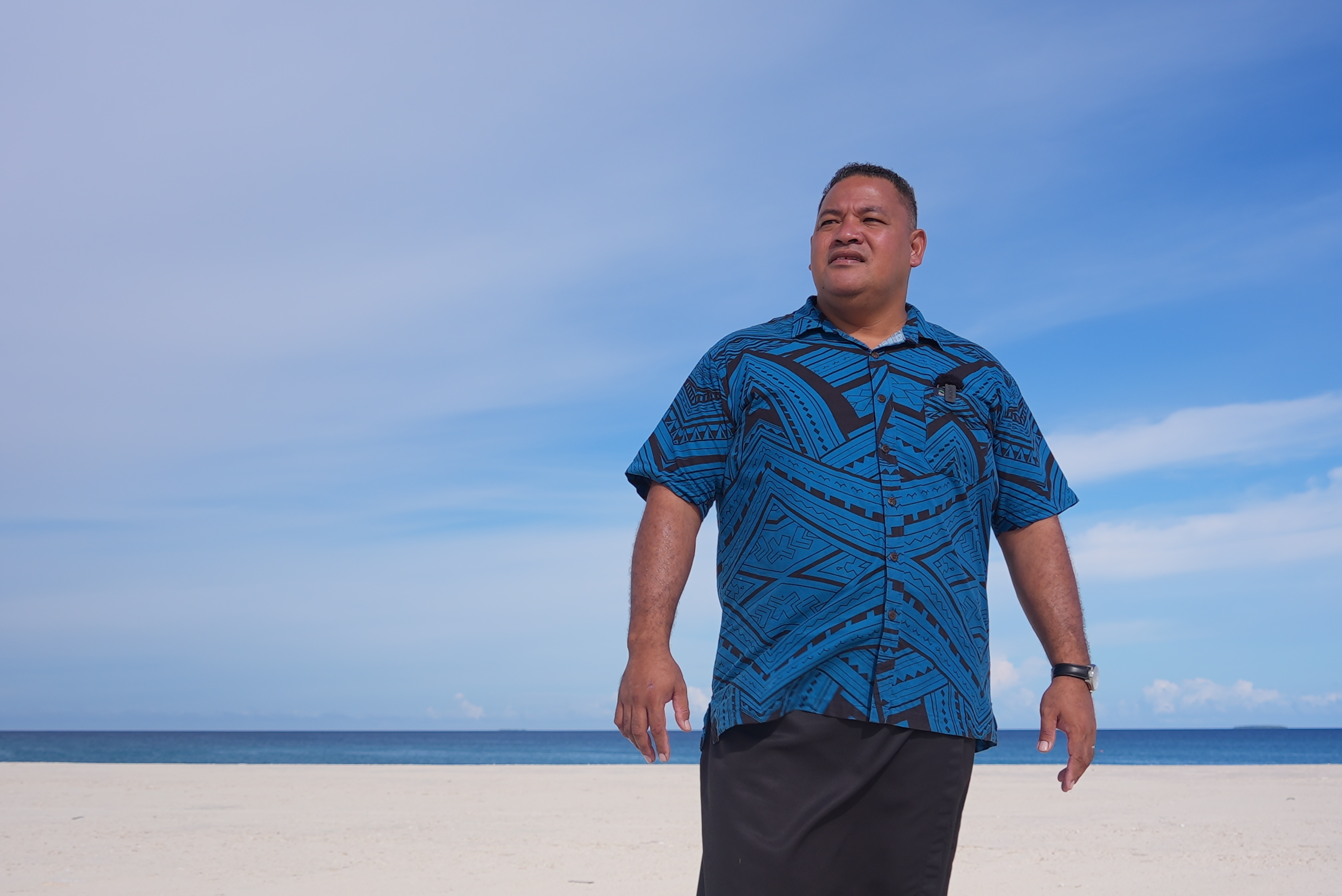 Tuvalu climate change minister Maina Talia stands on newly built land on the shoreline where his house used to sit.