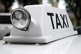 A taxi sign on top of a taxi