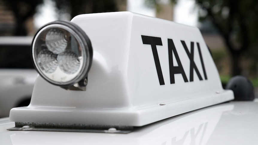 A taxi sign on top of a taxi