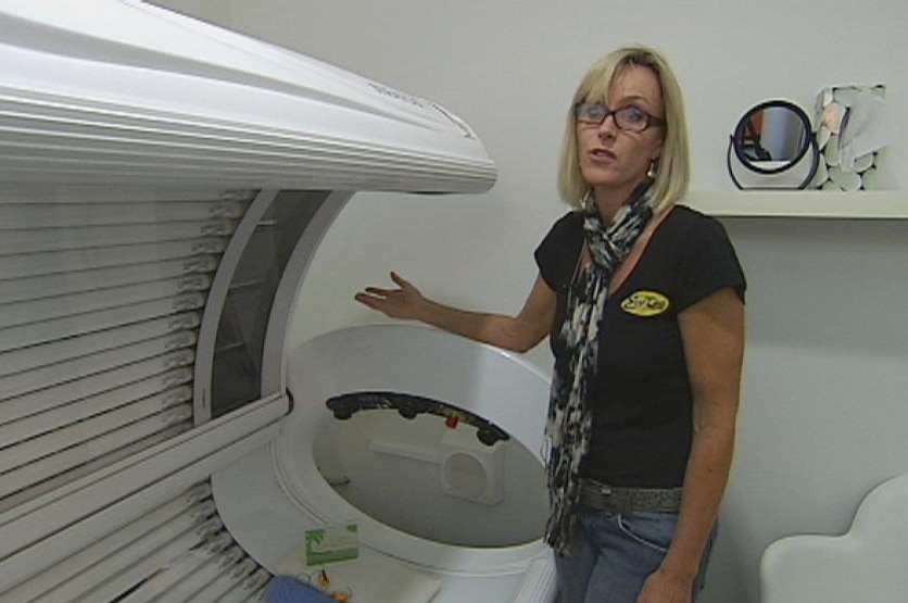Solarium owner Samantha points to a tanning bed in Perth