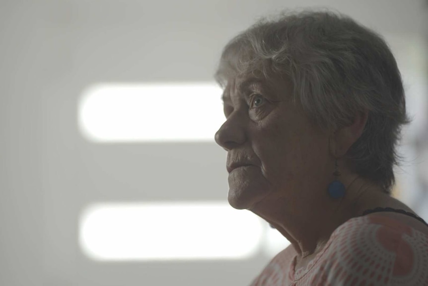 Woman with short grey hair looks up