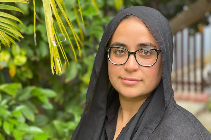 Hulya Candemir standing in a garden, wearing a head scarf.