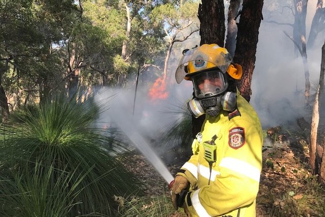 Un pompier pulvérise de l'eau vers les flammes
