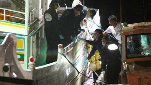 Taiwan policemen inspect bullet holes on the "Guang Ta Hsin 28" fishing boat.