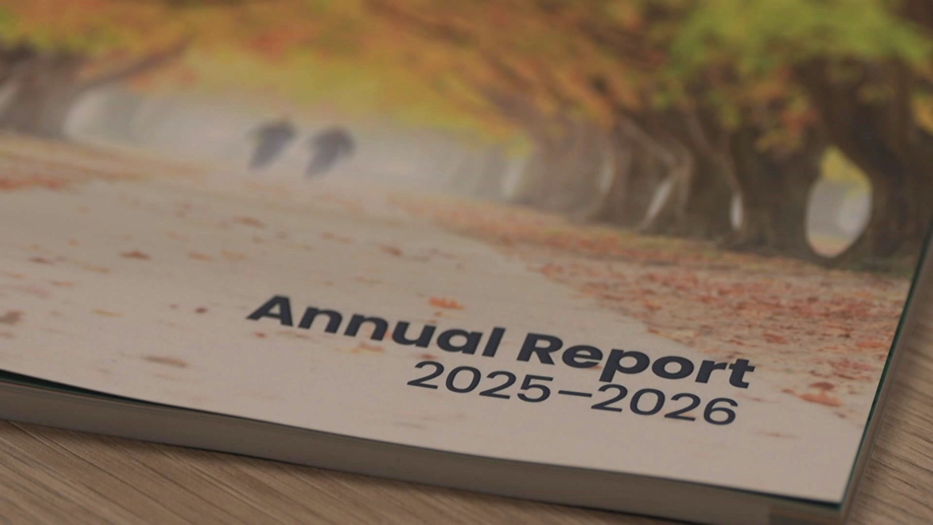A close-up view of a bound report that reads "Annual Report 2025-2026" sitting on a table.