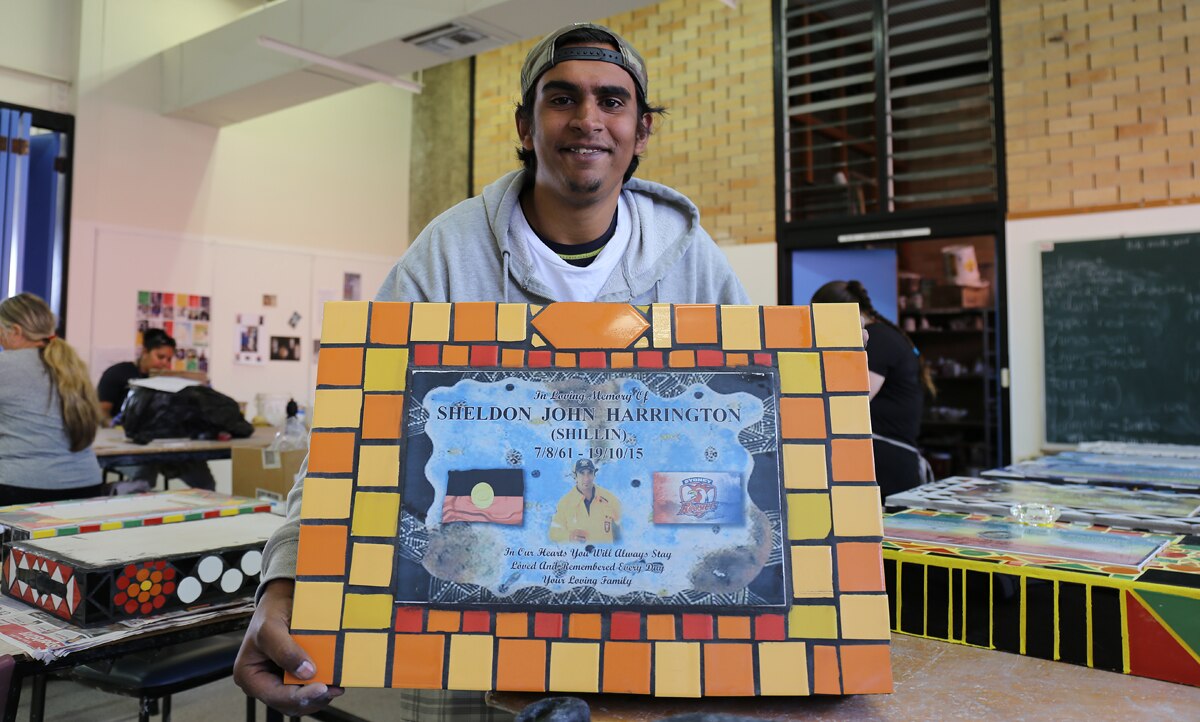 Brandon Harrington holds the headstone he made for his father Sheldon Harrington.