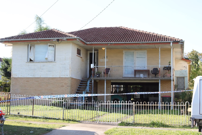 A two storey house with police tape across the front.