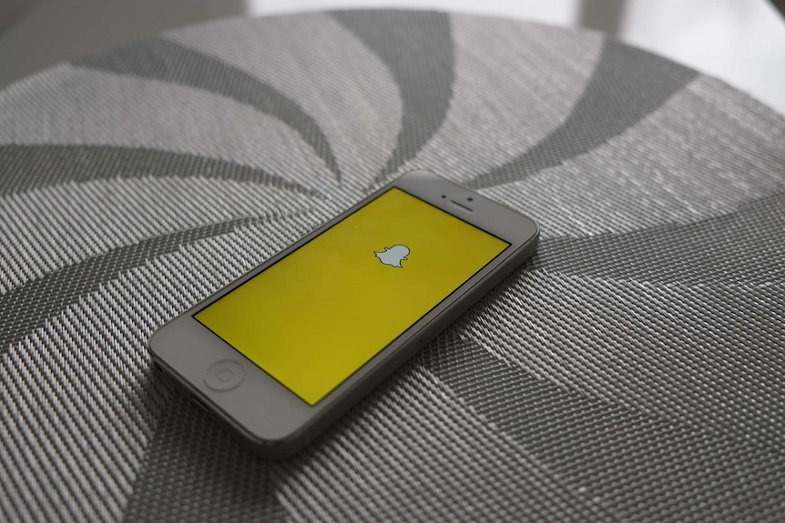 Snapchat app loaded onto an iPhone, sitting on a surface