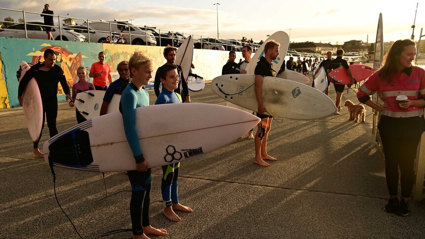 A large group of surfers waits as Bondi Beach is re-opened