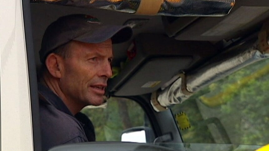 Tony Abbott sits in a firefighter truck