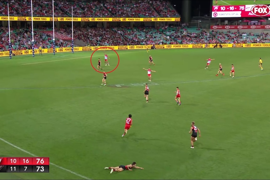 Aussie rules players throwing their hands in the air wanting the ball from their teammate who is taking a free kick in a game