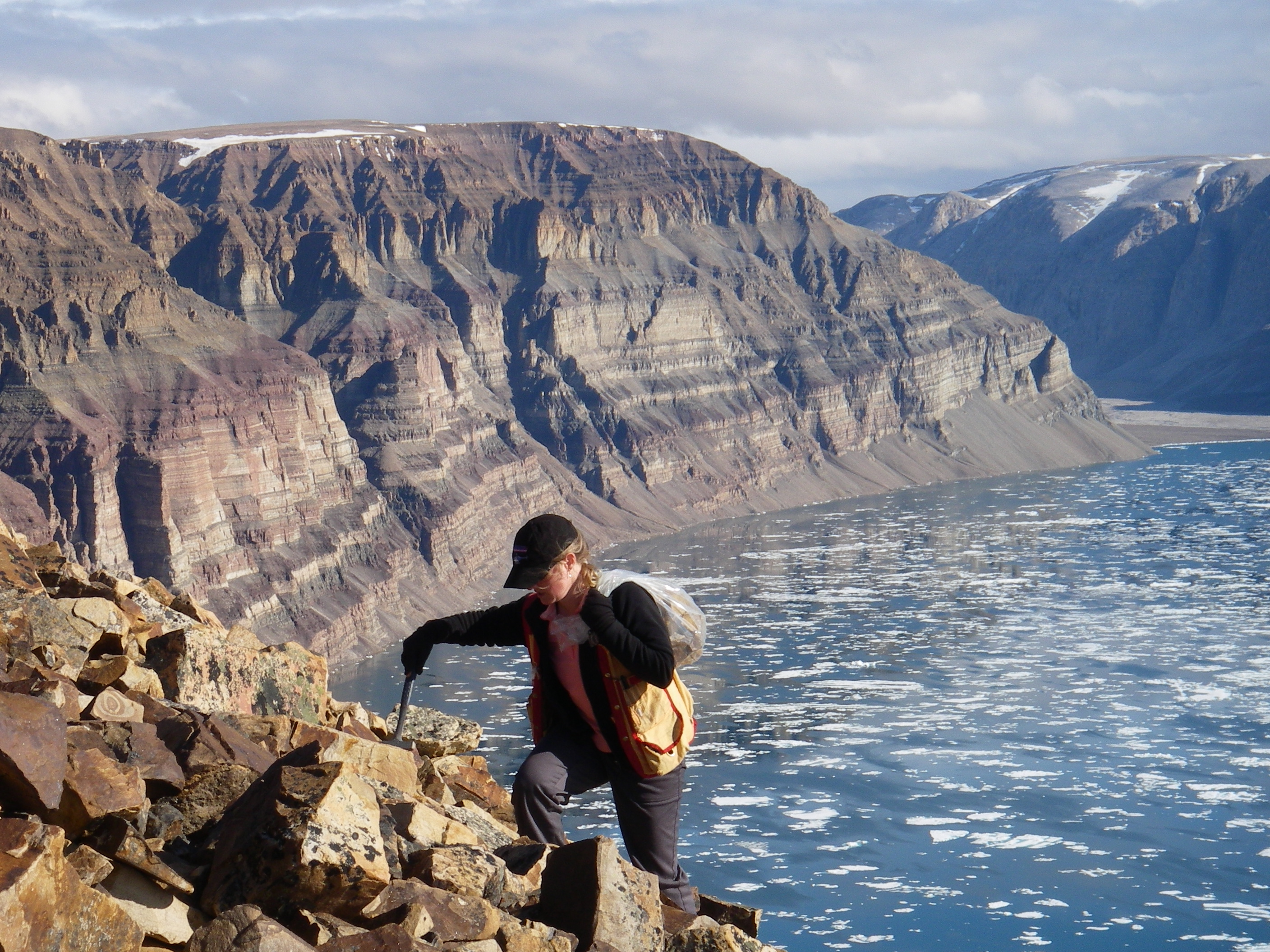 Woman hiking over rocks near a lake 