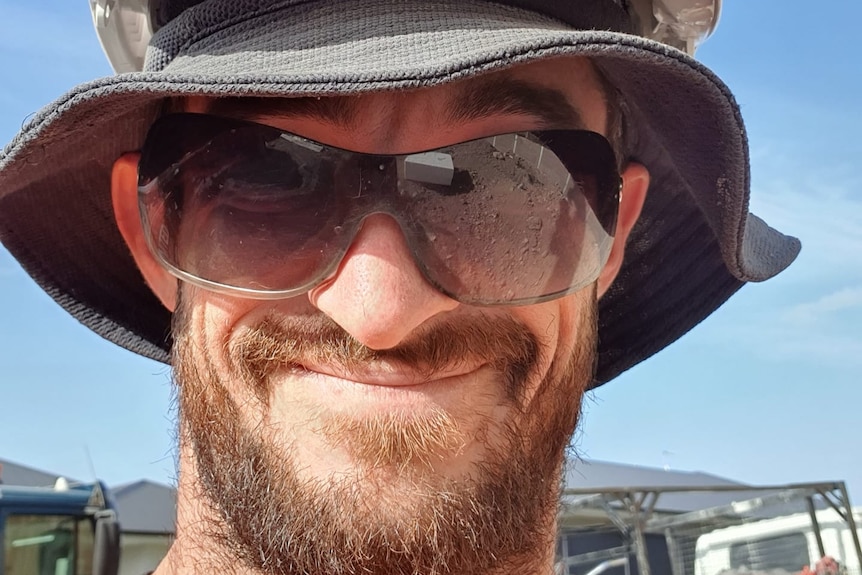 Headshot of Brisbane man Jordan Van Doorn, wearing two hats, sunglasses and smiling.