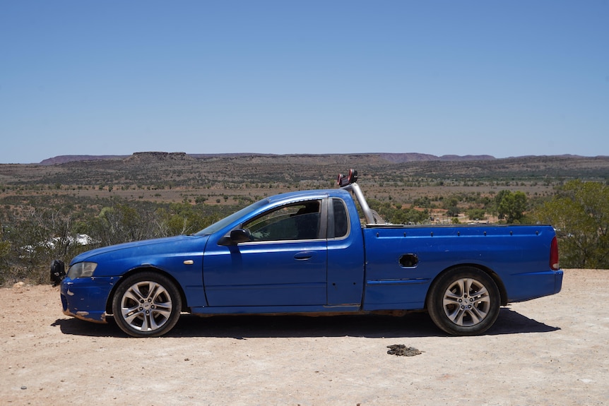 A blue Ford ute overlooking mountains