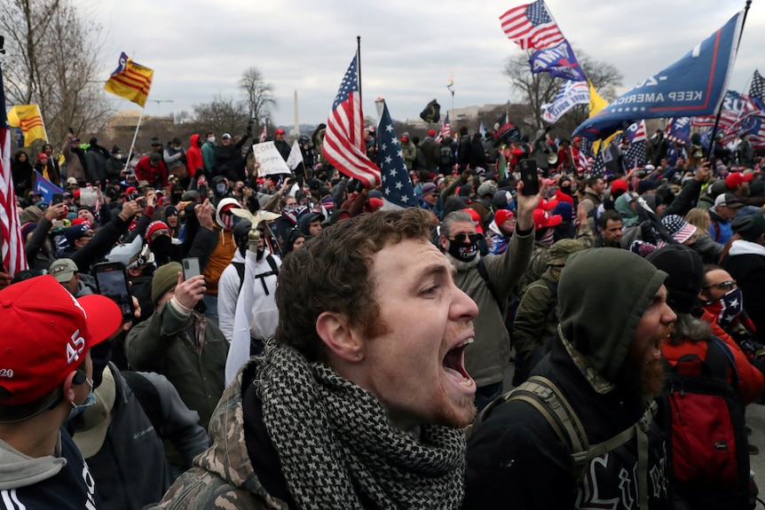 Zbliżenie mężczyzny krzyczącego na tłum popierających Trumpa uczestników zamieszek na Kapitolu Stanów Zjednoczonych w Waszyngtonie.