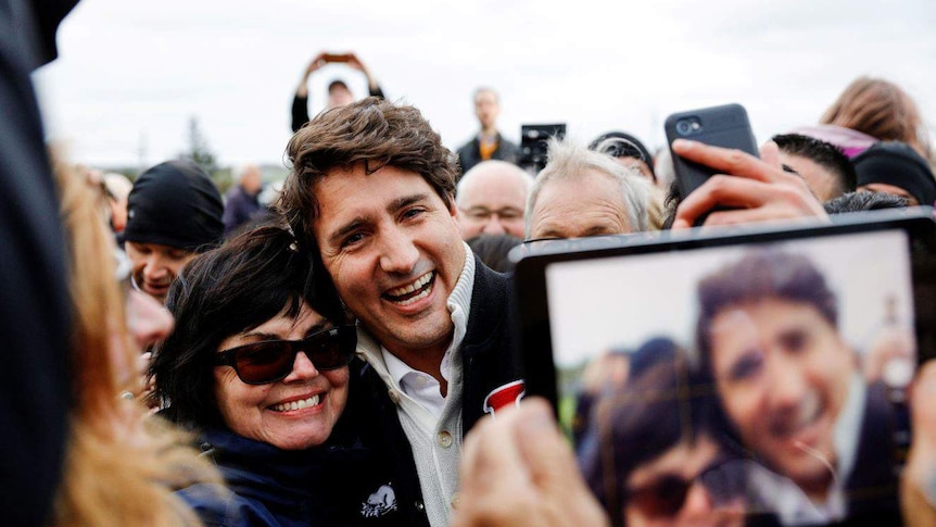 Justin Trudeau hugging a supporter while posing for a photo