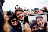 Justin Trudeau hugging a supporter while posing for a photo