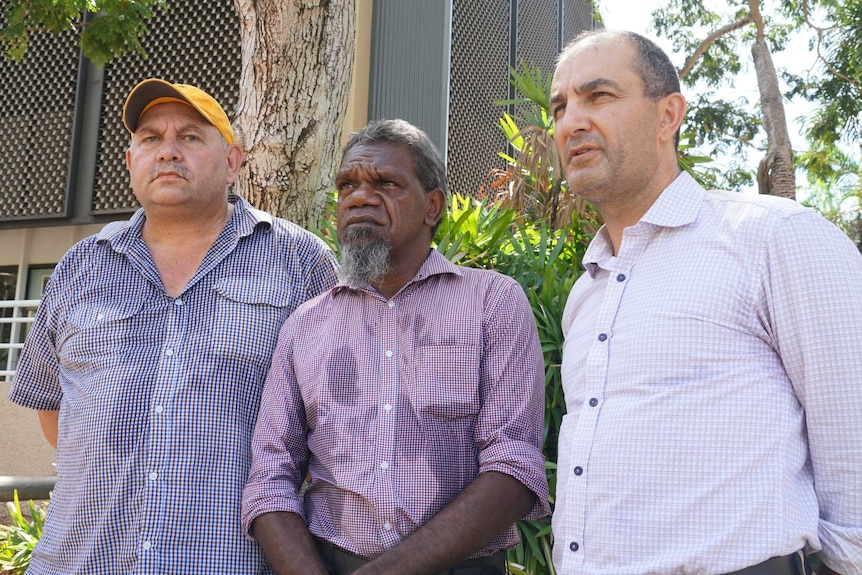 Three men looking steely-eyed peer into the distance.