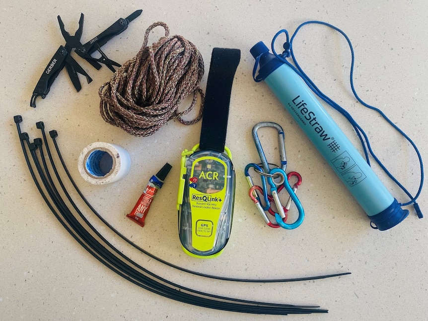 Image of items including a personal locator beacon, cable ties, water purifier, rope, duct tape , multipurpose knife.