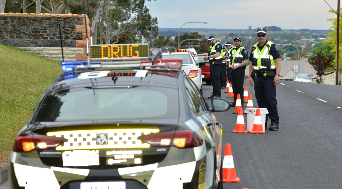 Police smile while standing at a roadside testing station