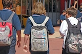 School boys walking with backs to camera.
