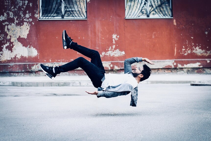 A man lies horizontally, hovering above the ground.