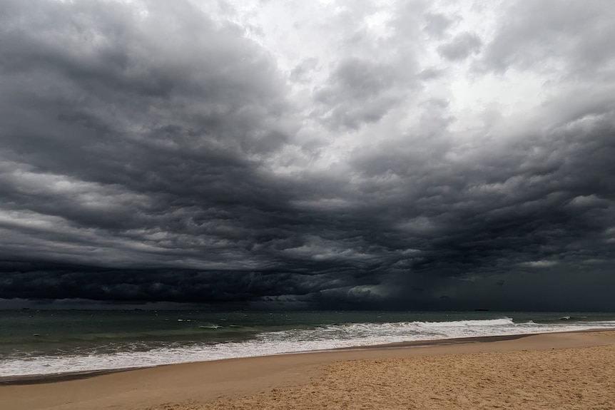 Dark storm clouds over a Queensland beach