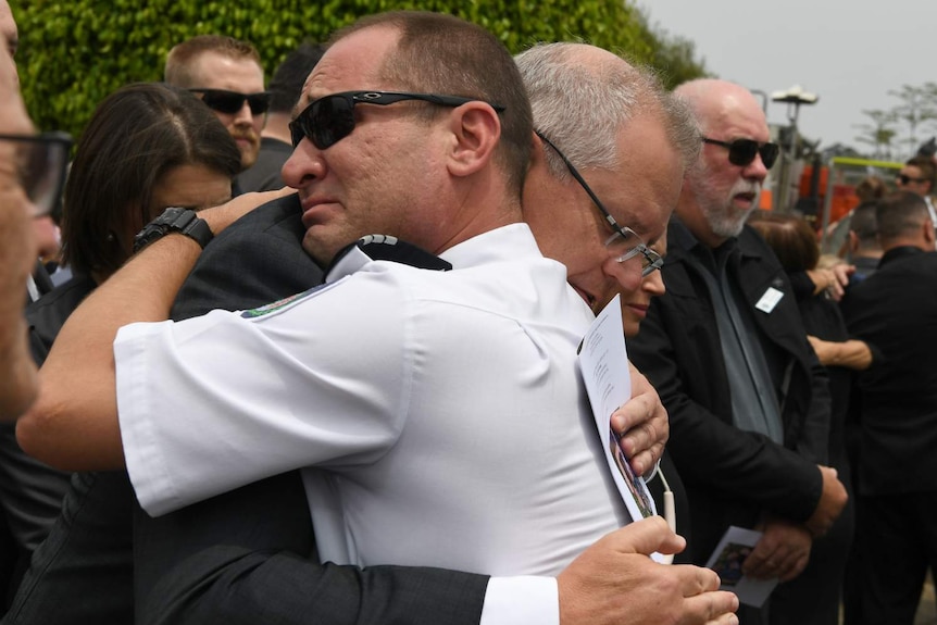 Prime Minister Scott Morrison hugs Horsley Park RFS captain Darren Nation at the funeral of Andrew O'Dwyer.