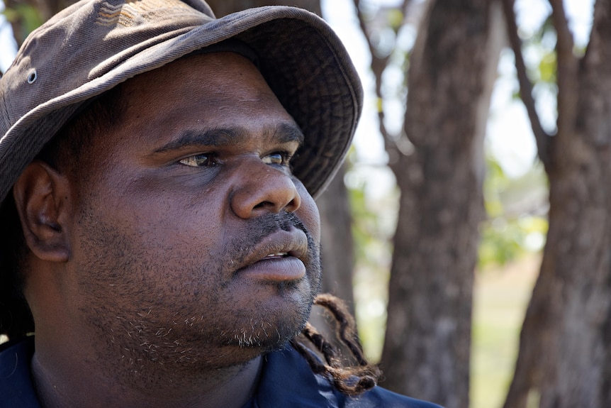 A close-up of the face of a young Aboriginal man looking into the distance