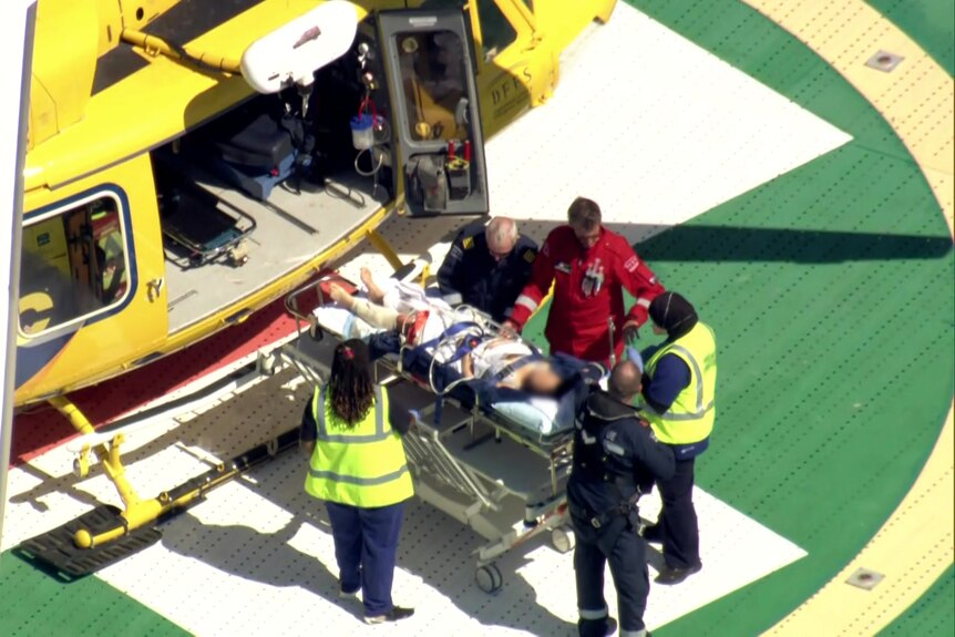 A woman on a stretcher being taken out of a helicopter. 