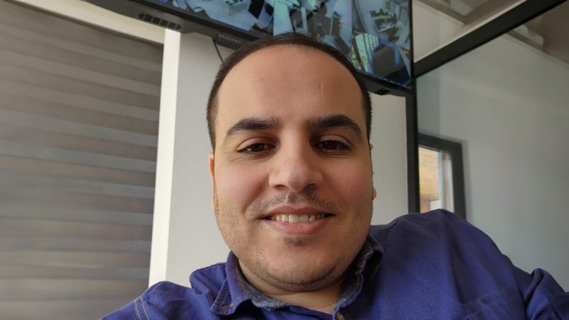 Diaa smiles and looks at the camera.