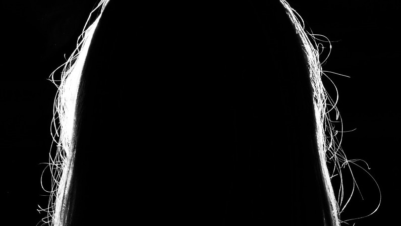 A silhouette of a women with long hair, no facial features are showing