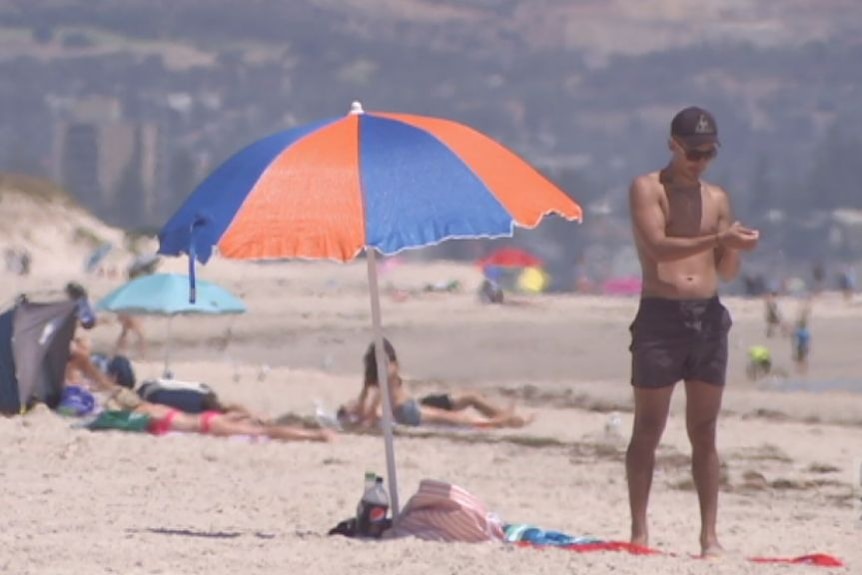 People lay on the beach in warm conditions