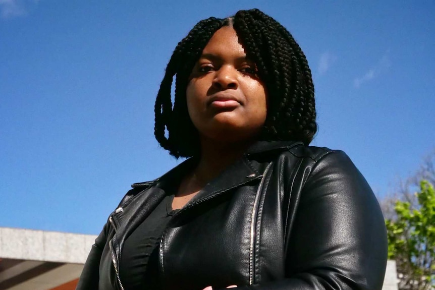 Dressed in a leather jacket, Lavina Luboya stands outside the Federal Court building in Melbourne.