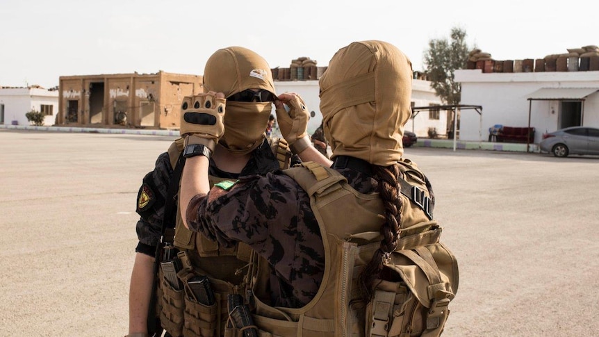 Arab women from the special forces who're trained by the Kurds adjust their mask before they start a training sessio