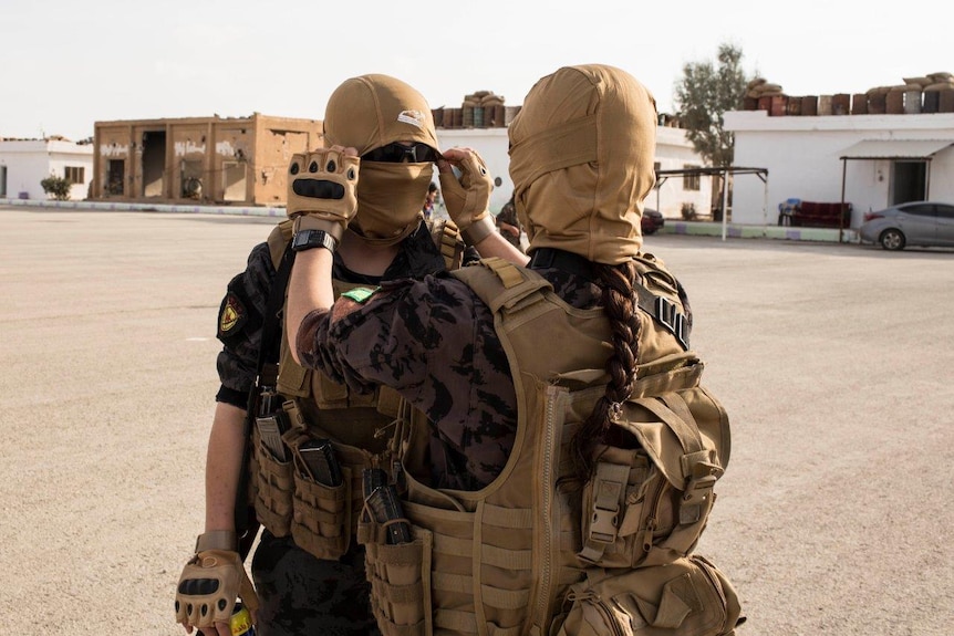 Arab women from the special forces who're trained by the Kurds adjust their mask before they start a training sessio