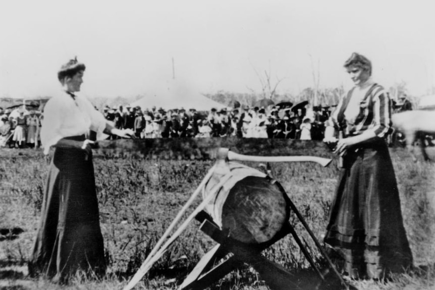Lynch sisters demonstrating their wood sawing skills at an early Brisbane Exhibition.