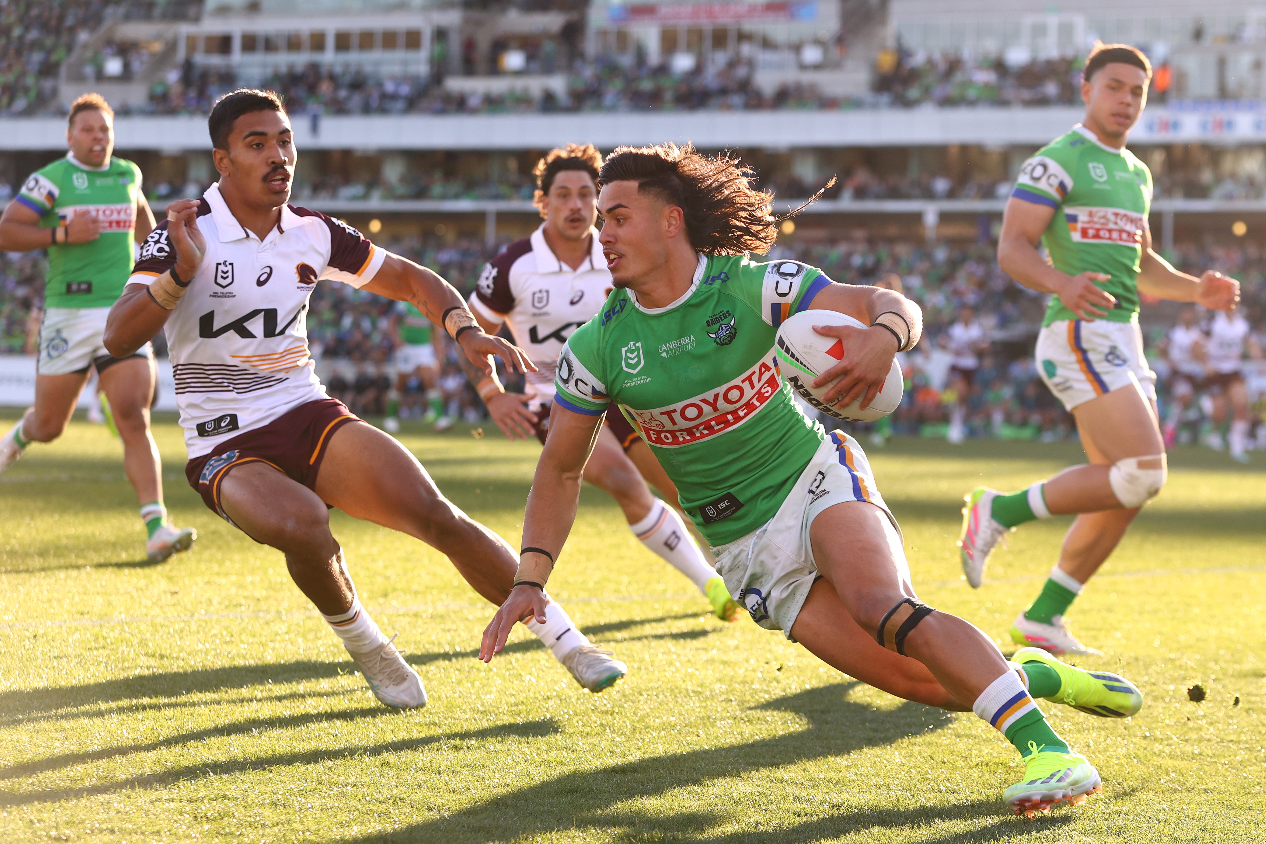 A man runs the ball during a rugby league match.