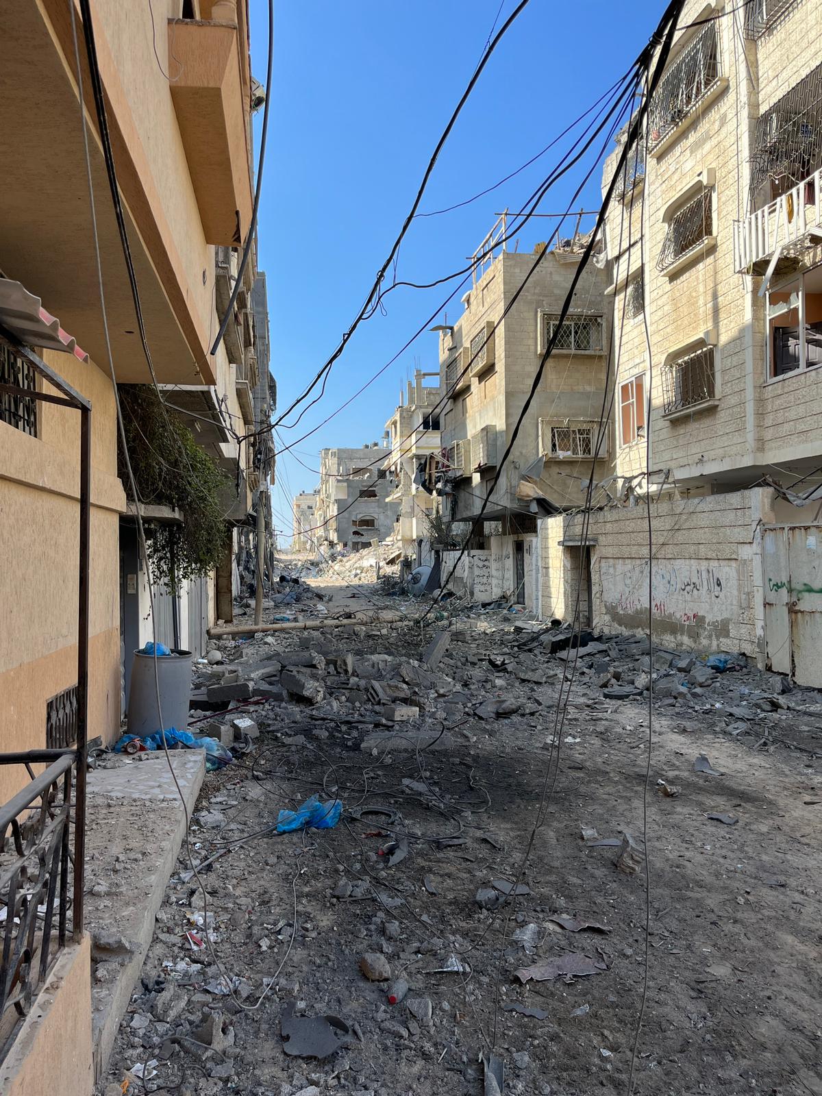 Street in Northern Gaza after explosion, hole in road surprised by debris and rubble