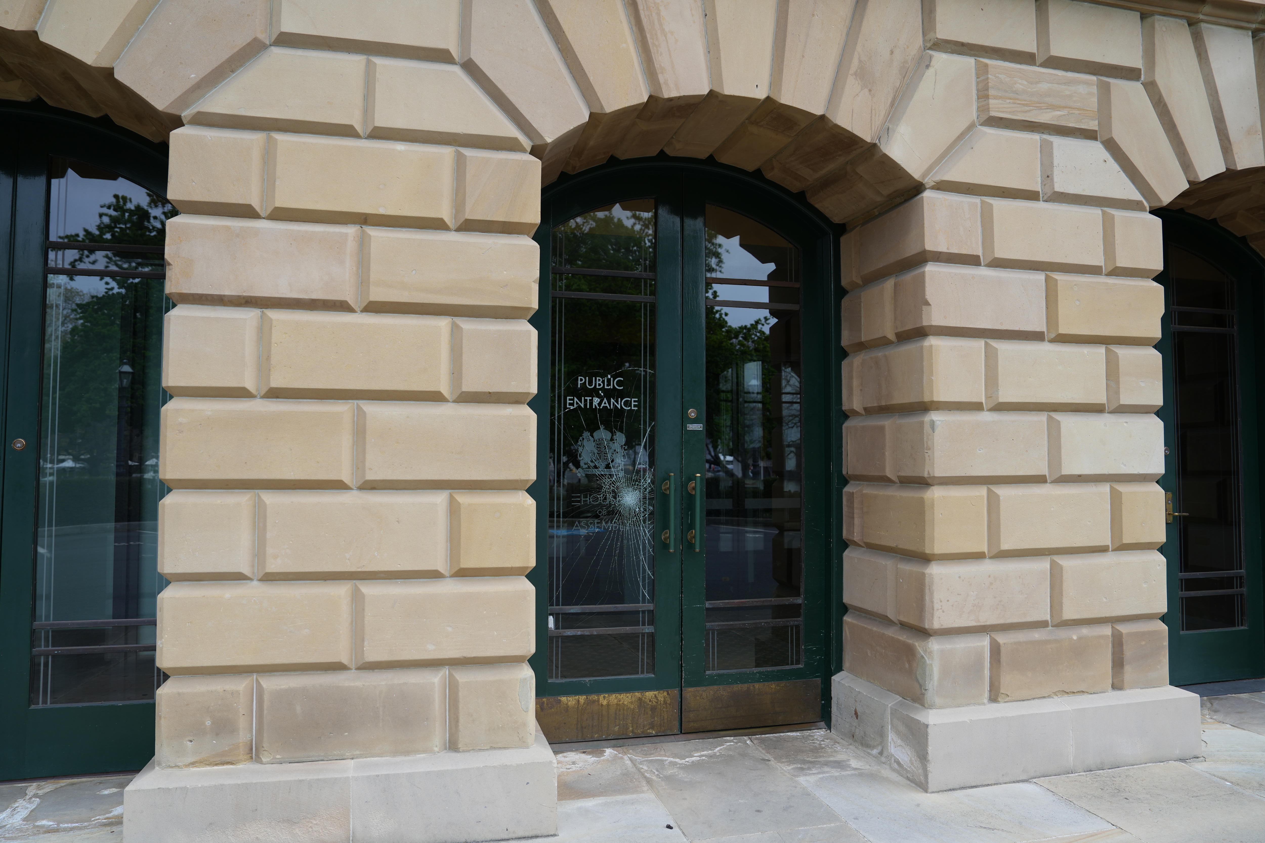 A damaged glass door in a sandstone building