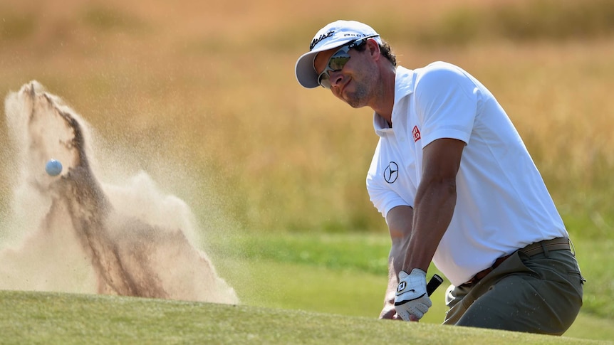 Adam Scott plays out of the bunker at The Open